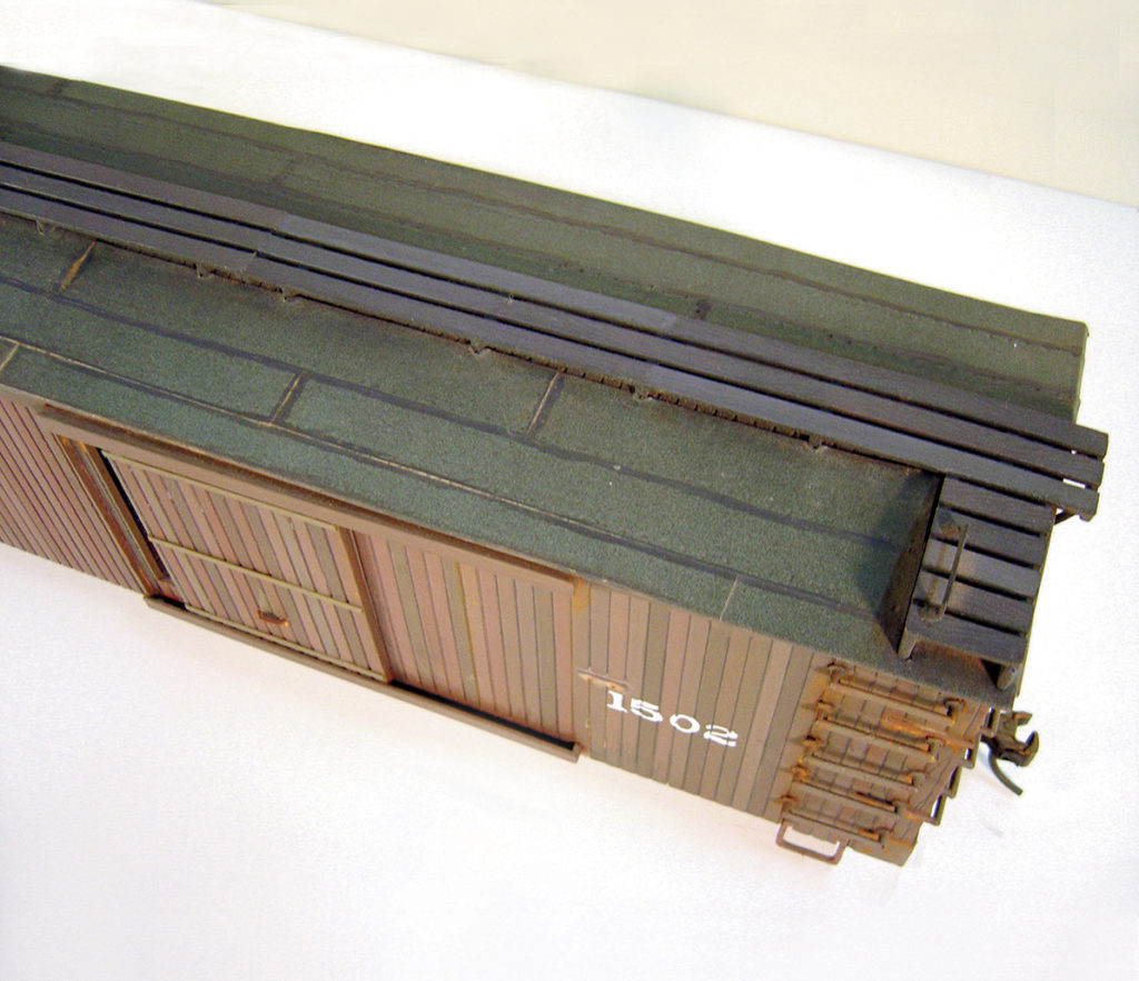 Black masking tape forms a faux tarpaper roof on this boxcar. 