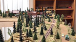 A model train passes by a small town.