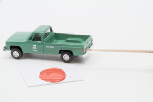A toothpick, a reddish-colored puddle, and a green HO scale pick-up truck which had the puddle fluid applied to the taillights