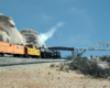 A Union Pacific refrigerated boxcar train gets pushed upgrade in a desert scene west of California's Cajon Pass.