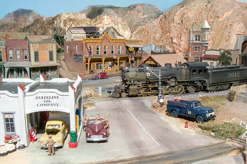 Santa Fe 2-10-2 no. 3012 is under a slow order as it rolls through a Cuyama grade crossing, since the wig-wag signals are being repaired.