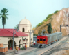 A Santa Fe doodlebug and passenger car pause in front of a scratch-built passenger station.