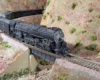 Close-up shot of an HO Scale 4-8-4 Santa Fe steam locomotive hauling an express train through a gorge.