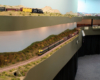 A vertical photo showing narrow gauge Rio Grande trains on an upper level of the layout and standard gauge Santa Fe trains underneath.