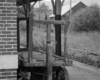 Black-and-white image of wooden baggage cart at an abandoned train station.