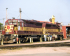 Crimson and yellow-striped locomotives under sunny skies.