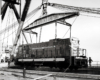 Diesel electric locomotive hovering above a hole from a large crane or hoist.