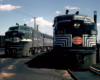 Two cab unit-style diesel locomotives appear in a rail yard.