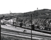 Three CN locomotives take the lead of a passenger train in a rail yard.