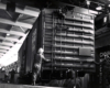 Workers manipulating boxcar inside a warehouse.