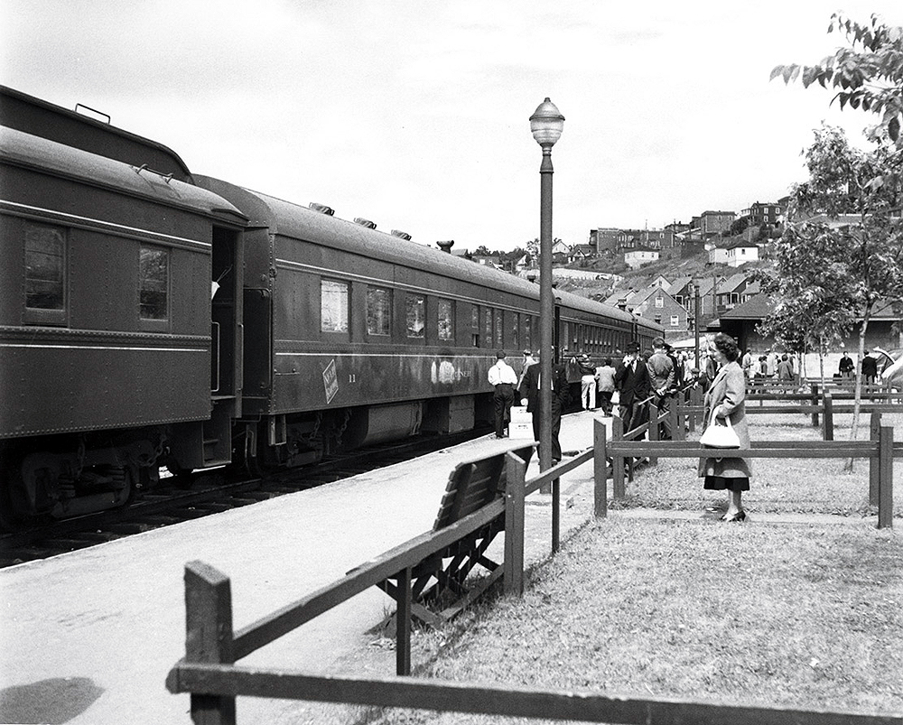 Passenger train at a station surrounded by passengers.