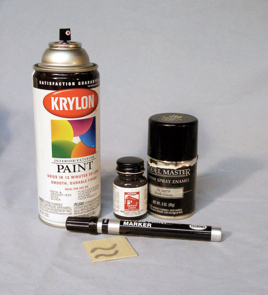 Assortment of enamel paint, spray paint, and a paint marker.