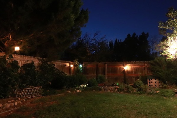 A backyard at night, with lanterns providing background light