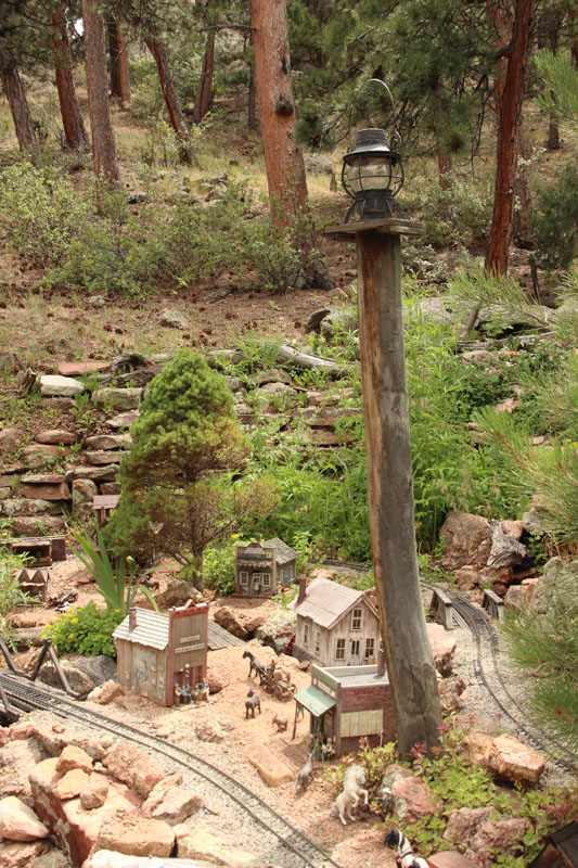 Garden railroad scene with lanterns on posts for nighttime lighting