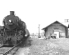 Front of a train pulled up next to a building