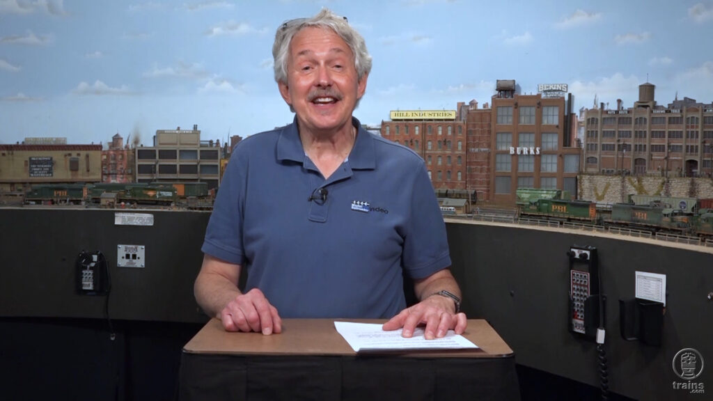 Gerry Leone standing in front of this HO scale model railroad