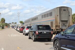 Line of cars next to a train