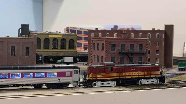 A locomotive pulls a train of Rapido 8600-series coaches around Steve Tello's HO scale model train layout.