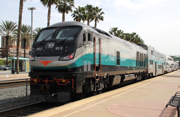 Silver, gray, and teai locomotive on commuter train