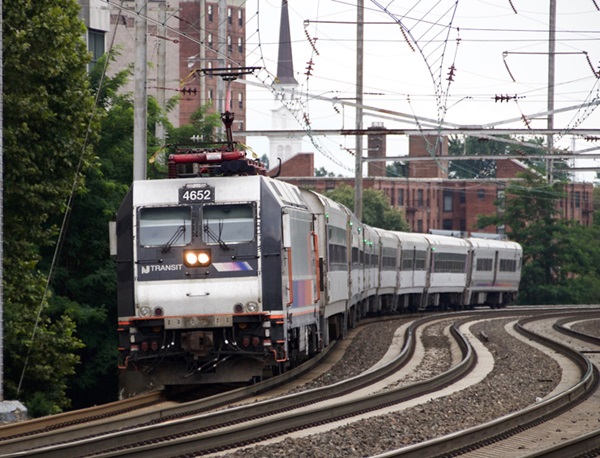 Electric locomotive hauls commuter train through S curve