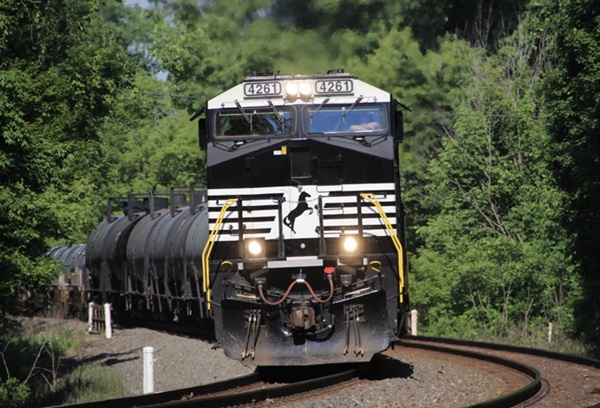 Black locomotives pulling tank cars