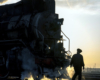 A silhouetted person in front of a steam locomotive.