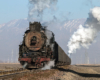 A steam locomotive hauls a train and seen in a classic North American three-quarter wedge image.