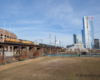 Yellow diesel locomotives hauling a tank car train on an elevated bridge.