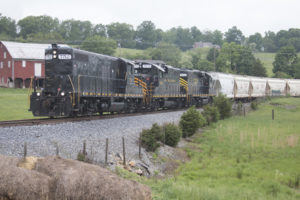 Black diesel locomotives on freight train in farm fields