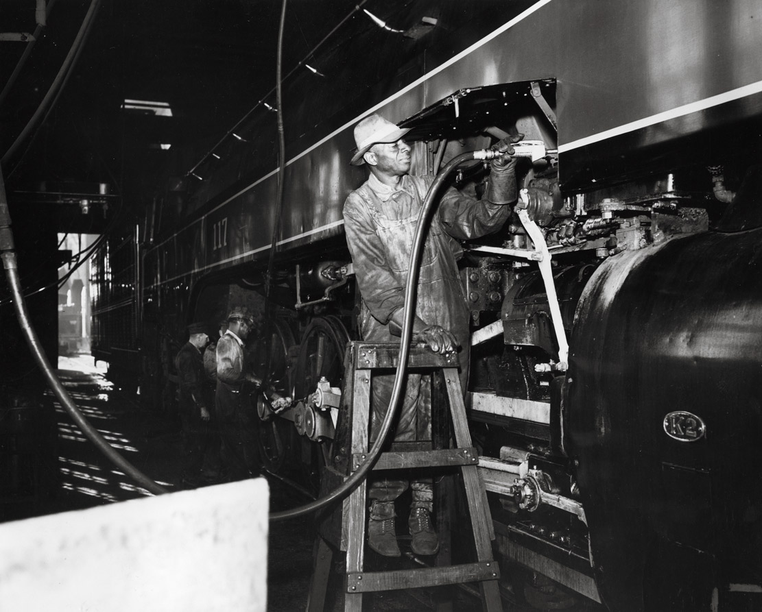 Worker lubricating steam locomotive