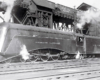 Black-and-white streamlined steam locomotive in a rail yard.