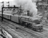 Streamlined steam locomotive at the head of a passenger train.