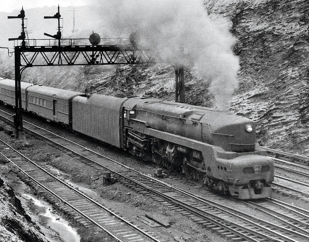 Streamlined steam locomotive at the head of a passenger train.