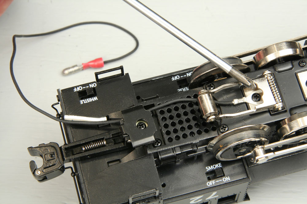 Wiring with male solderless connector is connected at the other end to the locomotive pickup screw with a spade connector. Wire is held to the locomotive body with a piece of double-sided tape