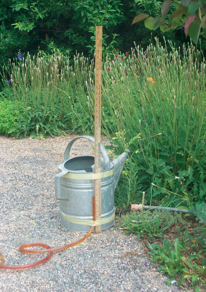 Homemade water level secured to watering can.