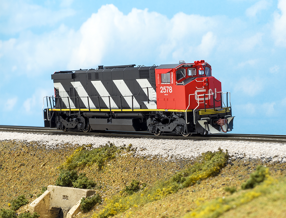 Red, black, and white Rapido HO scale Montreal Locomotive Works M420 diesel locomotive shown on scenicked track facing right