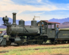 Three crew members stand around a 2-6-0 steam engine