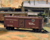 A brown steel boxcar lettered for the Turtle Creek Central RR, a fictional railroad, sits on a spur track