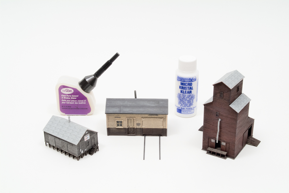 Testor’s Clear Parts Cement and Widow Maker and Microscale Kristal Klear with HO and Z scale laser-cut wood buildings.