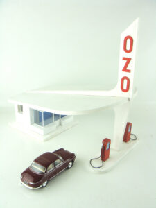 Miniature vintage gas station with car parked out by the pump
