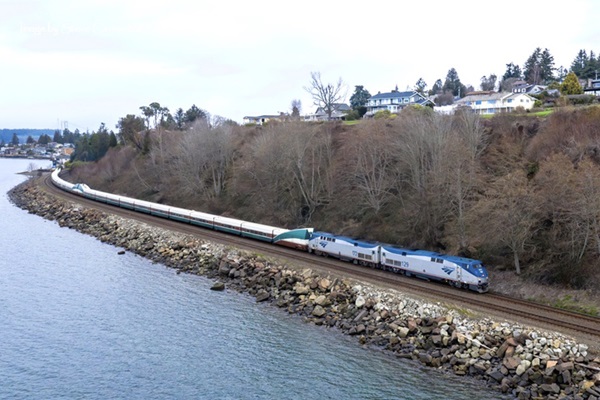 Train riding beside a body of water