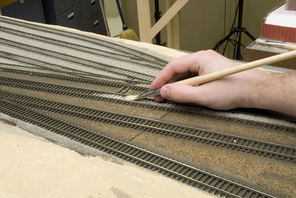 Spreading ballast with ½”-wide paint brush.