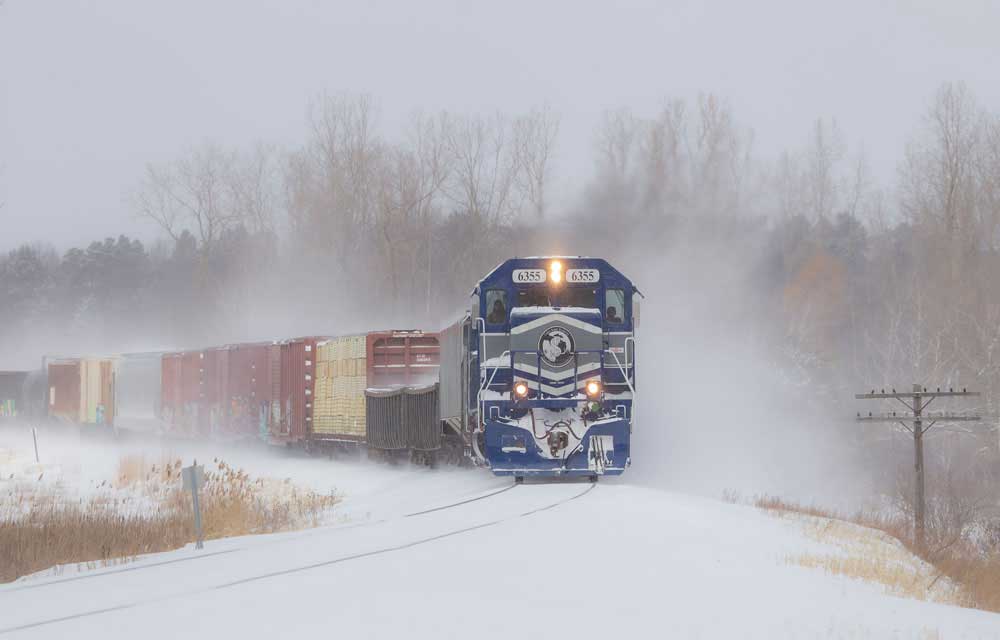 Train with blue and gray locomotive in snow