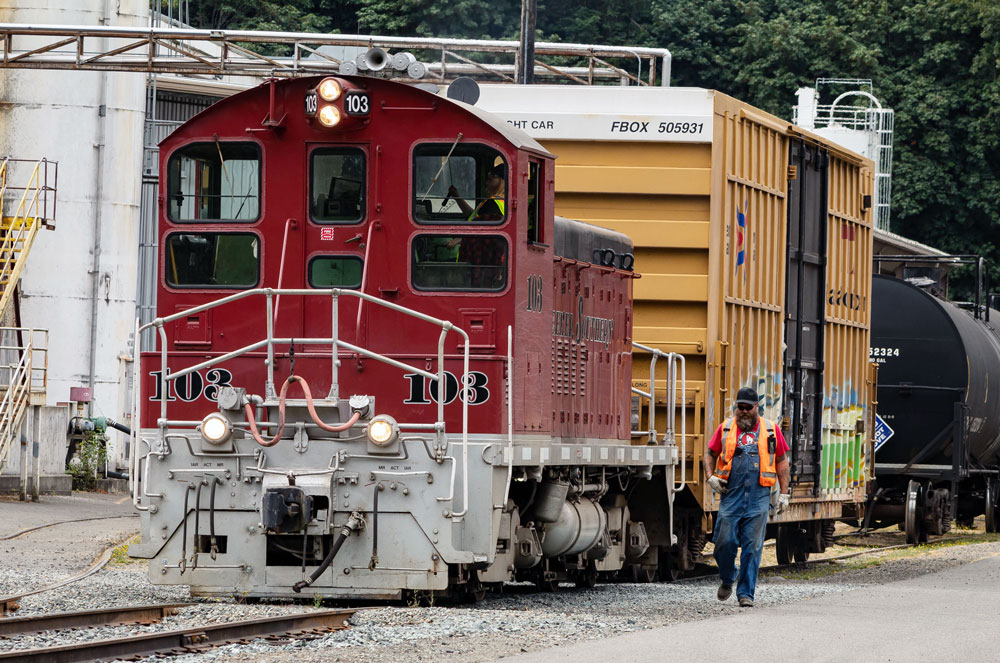 Red diesel locomotive switching freight cars.