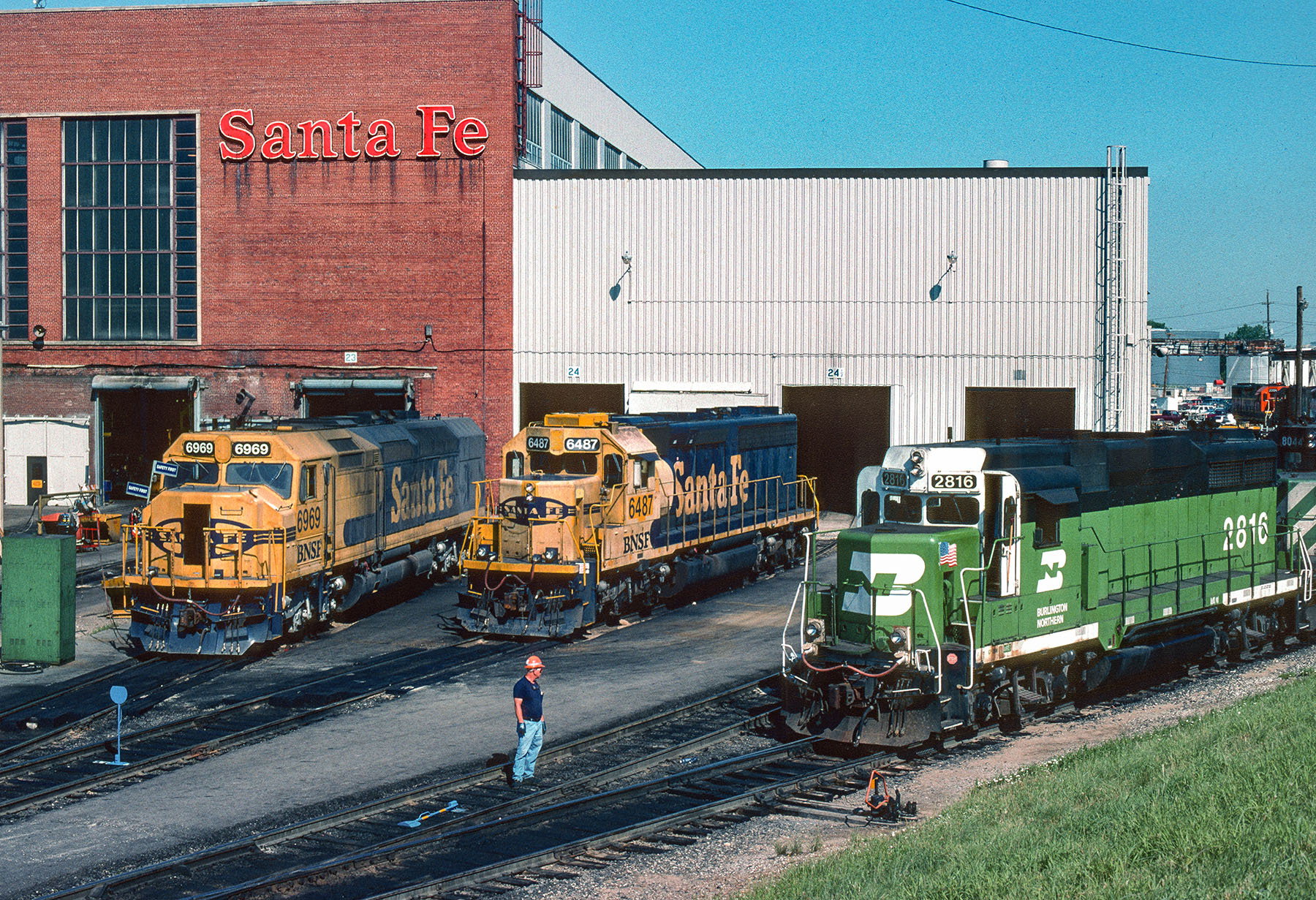 Three diesel locomotives outside shop building