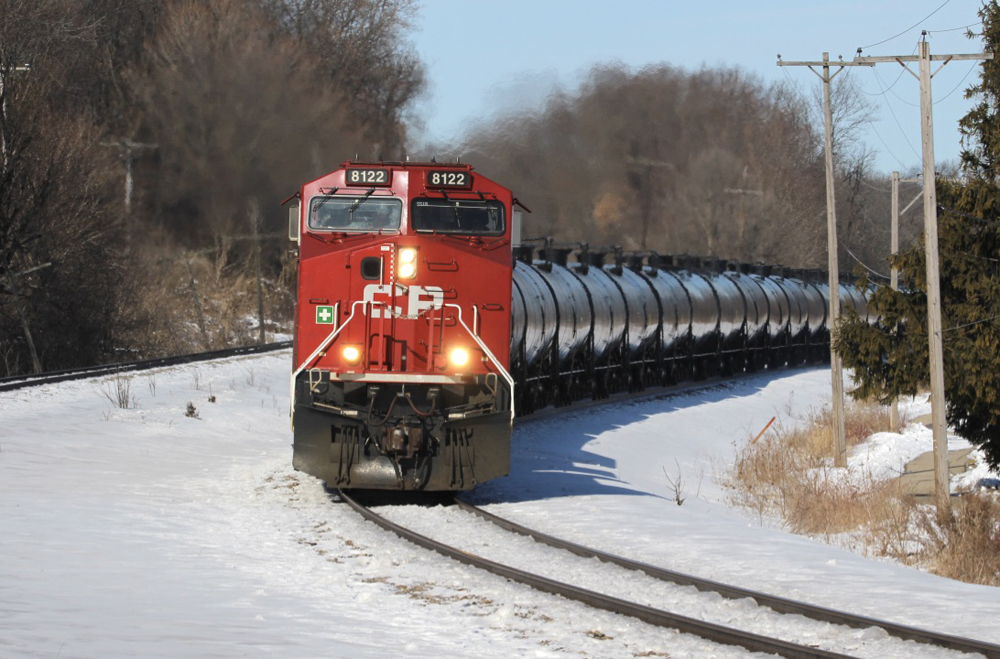 Train with tank cars rounding curve.