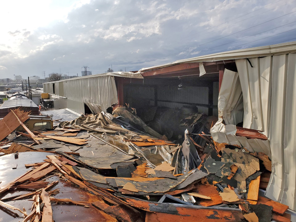 Building with part of wall missing, surrounded by debris