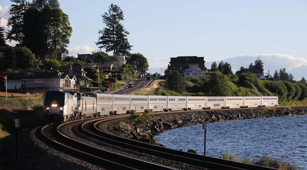 Passenger train running along shoreline