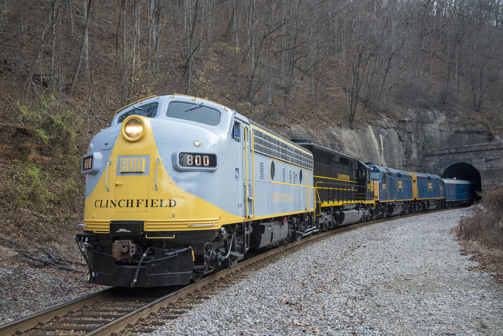 Train coming out of a hillside tunnel