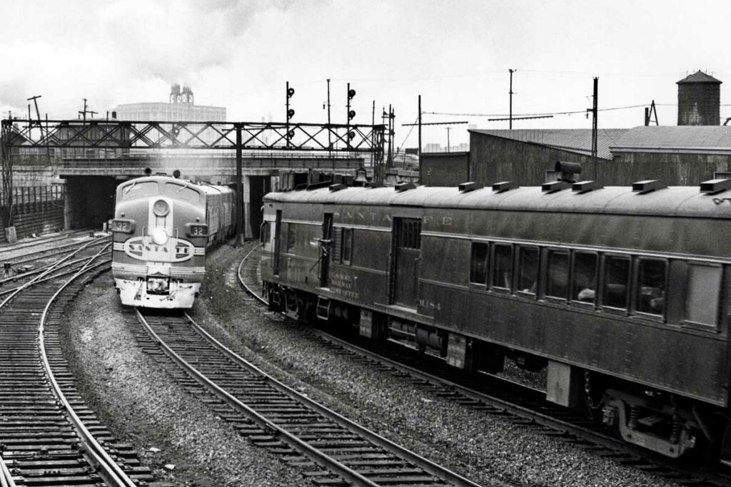 Passenger trains meet on curve under signal bridge